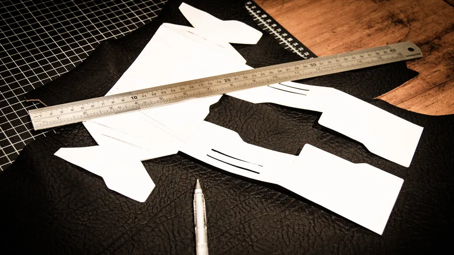 Papierschablone mit Lineal auf Lederoberfläche.