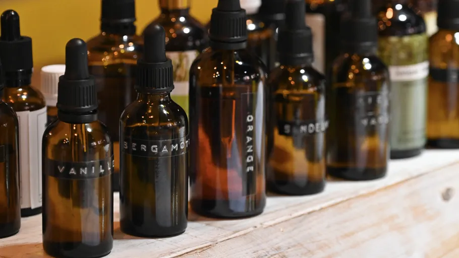 Flaschen mit Pipettendeckeln auf Holzregal.