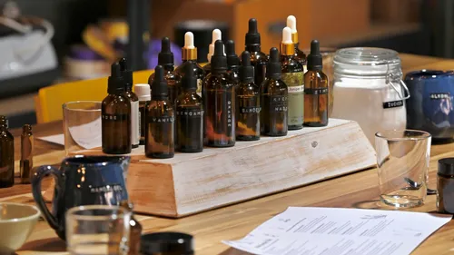 Aromatherapy bottles displayed on a wooden stand.