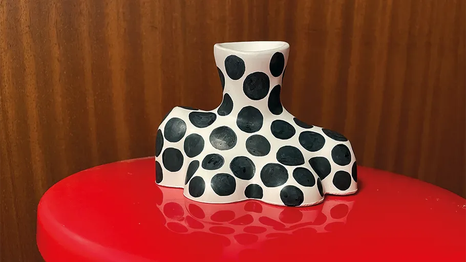 Polka-Dot-Vase auf roter Fläche, Holz-Hintergrund.