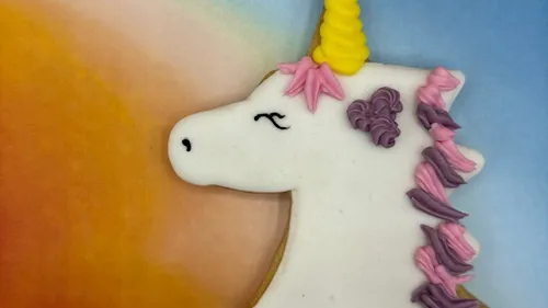 Einhorn-Keks vor Regenbogenhintergrund.