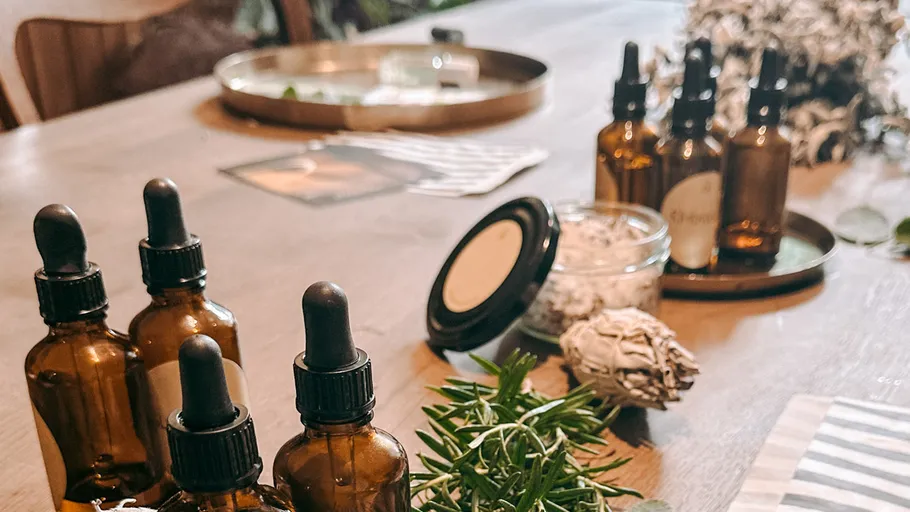 Bottles and herbs on wooden table.