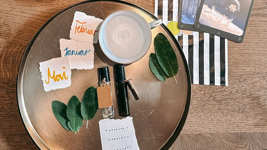 Tray with cards, cup, leaves, and perfume.