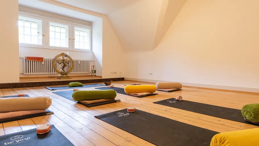 Yoga mats and cushions in a spacious room.