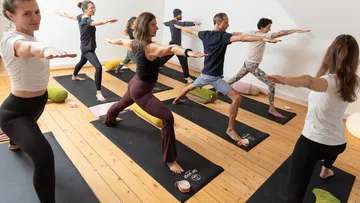 People practicing yoga poses in a studio.