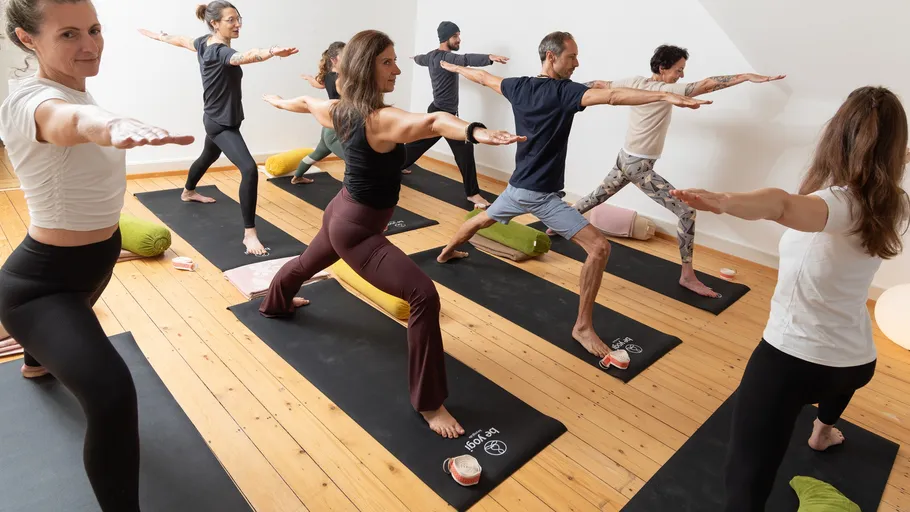 Menschen üben Yoga-Posen in einem Studio.