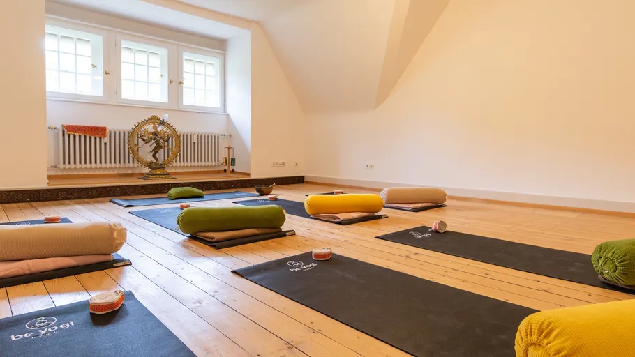 Yoga mats and cushions in serene studio.