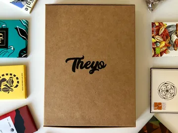 Brown box with the word “Theyó” surrounded by chocolate.