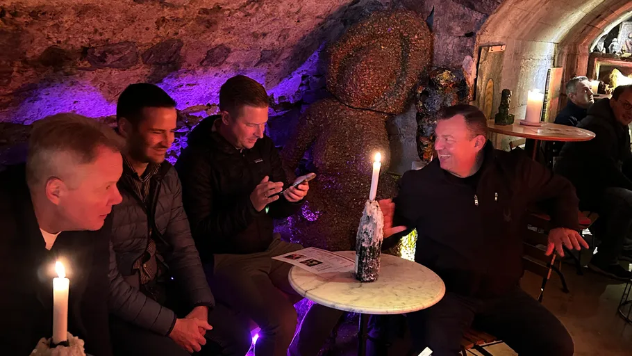 Men sitting in dimly lit underground cafe.