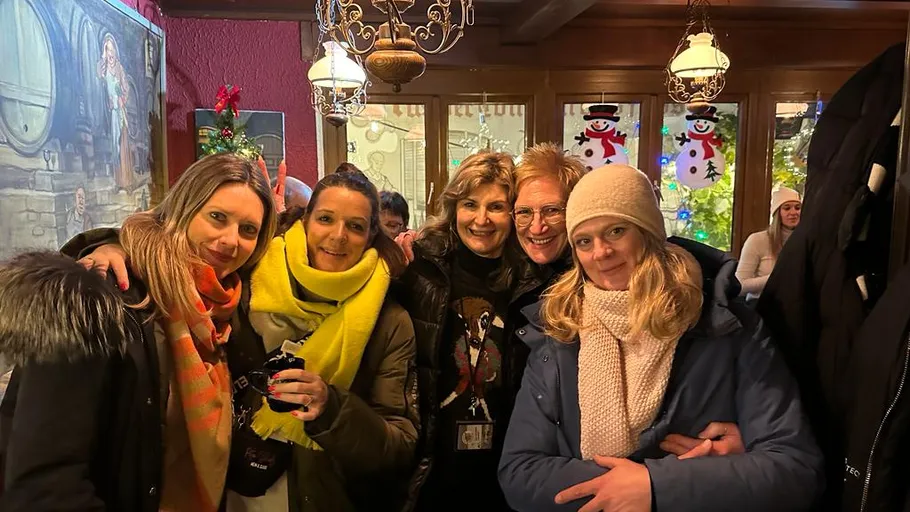 Five friends posing in cozy, festive room.
