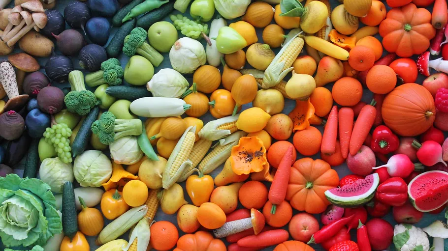 Variety of fruits and vegetables arranged by color.