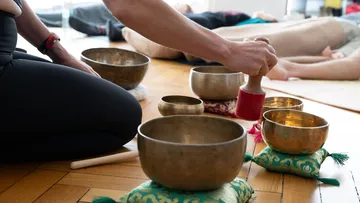 Person verwendet Klangschalen in einem Yoga-Studio.