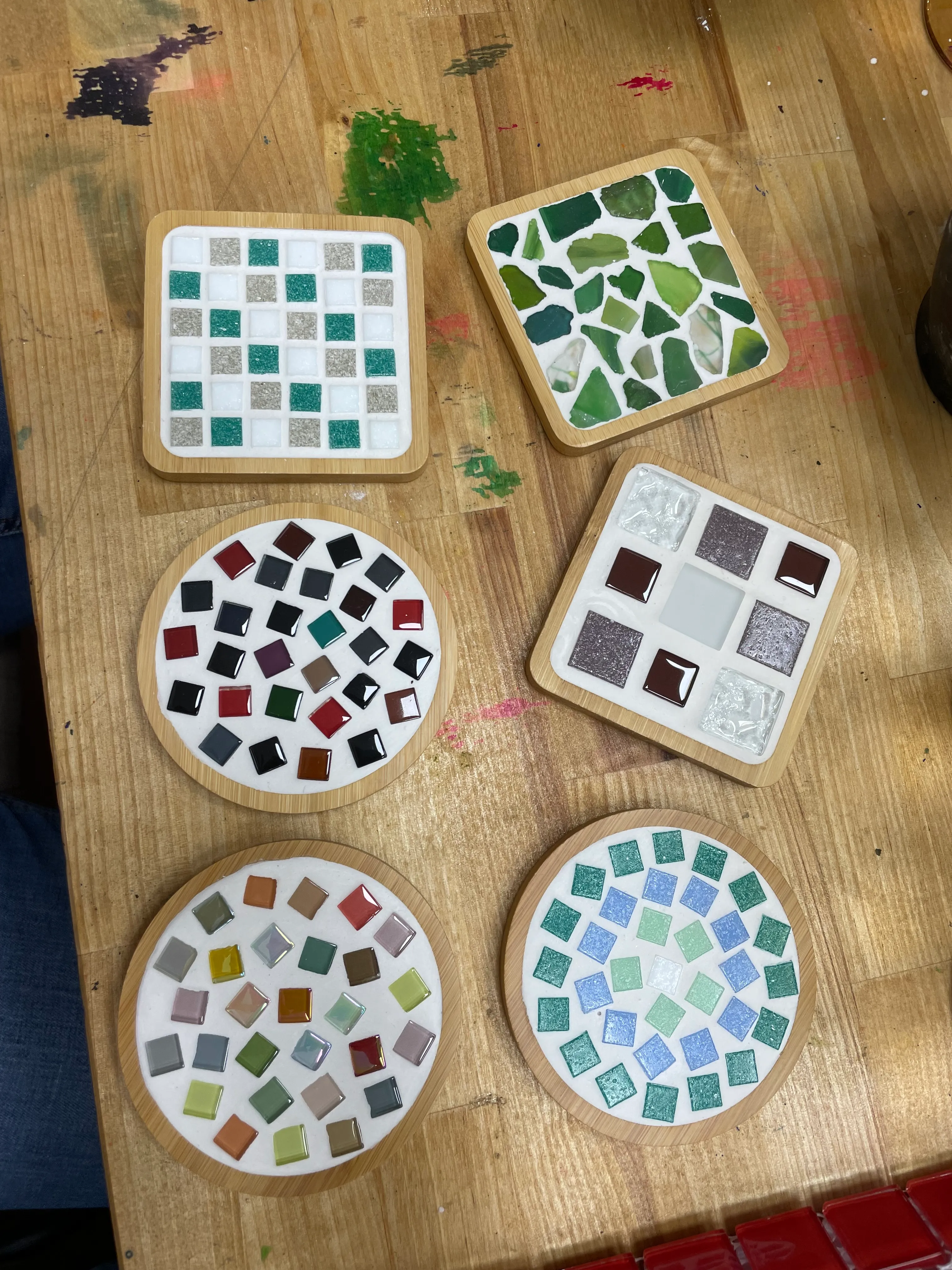 Bunte Mosaik-Untersetzer auf Holztisch.