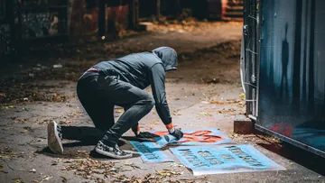Person sprüht Straßenkunst nachts.