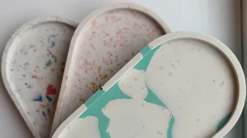 Drei Terrazzo-Tabletts mit bunten Mustern.