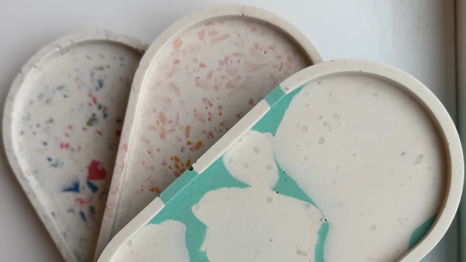 Three terrazzo trays with colorful patterns.