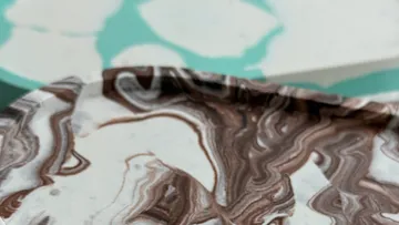 Marble-patterned plate on colored surface.