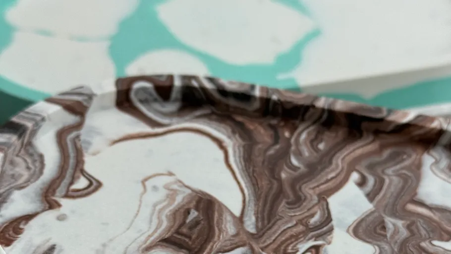 Marmorierte Platte auf farbiger Oberfläche.