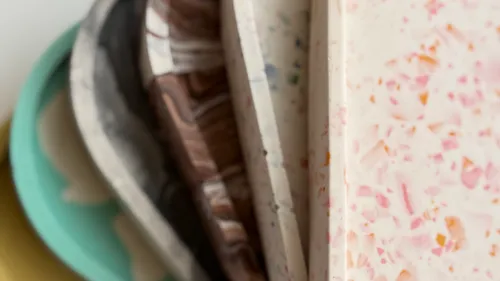 Gestapelte Terrazzo-Tabletts in verschiedenen Farben.