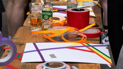 Buntes Klebeband und Getränke auf Holztisch.