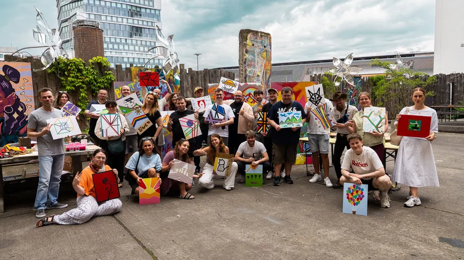 Group holding paintings outdoors, urban setting.