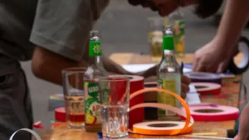 Leute schreiben an Tisch mit Getränken, Klebeband.
