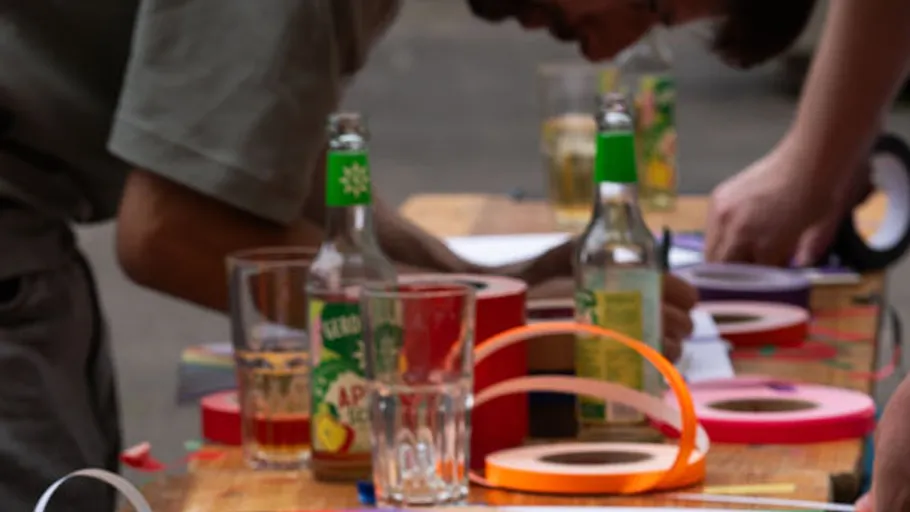 People write at table with drinks, tape.