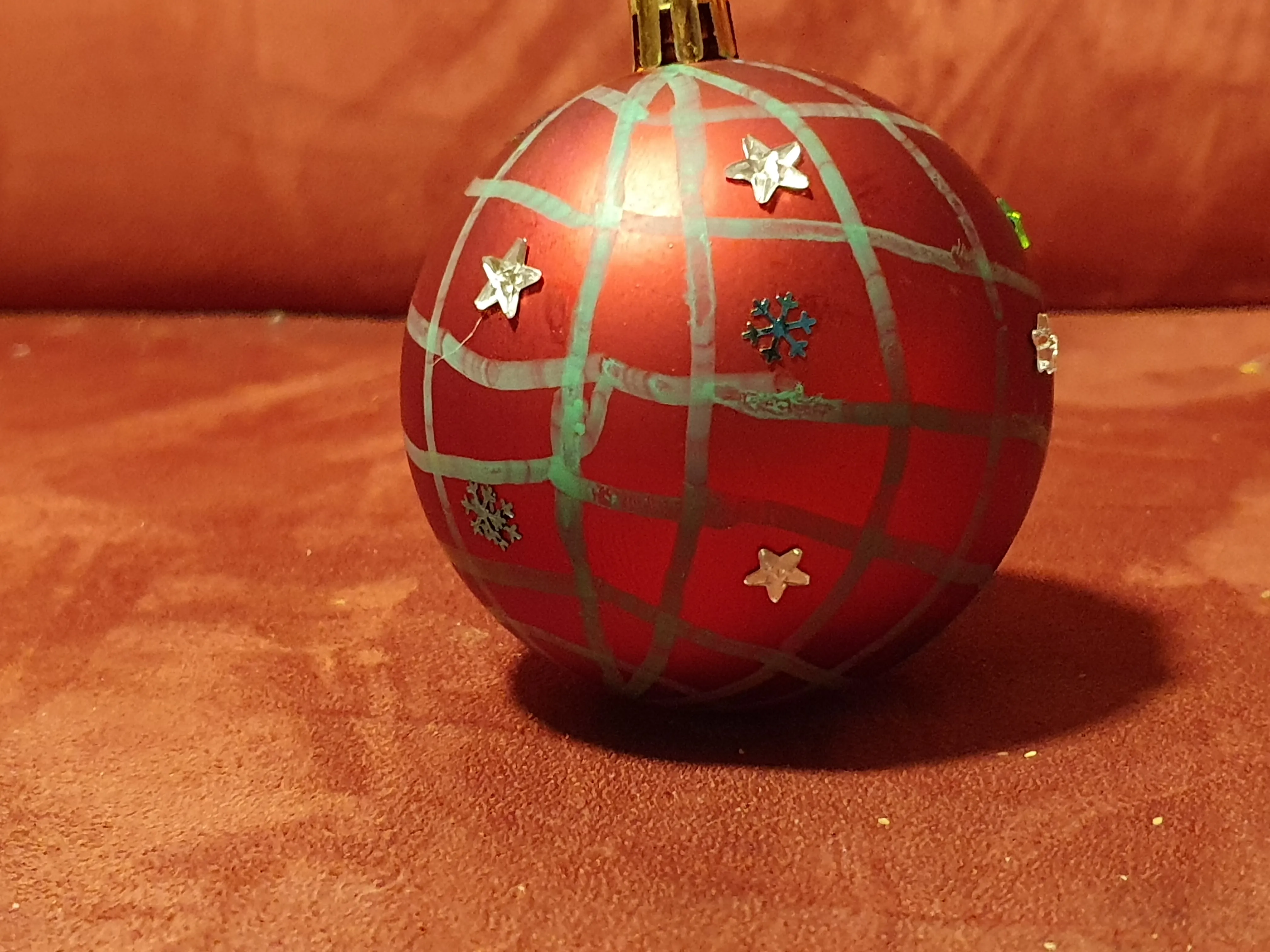 Red ornament with star decorations on sofa.