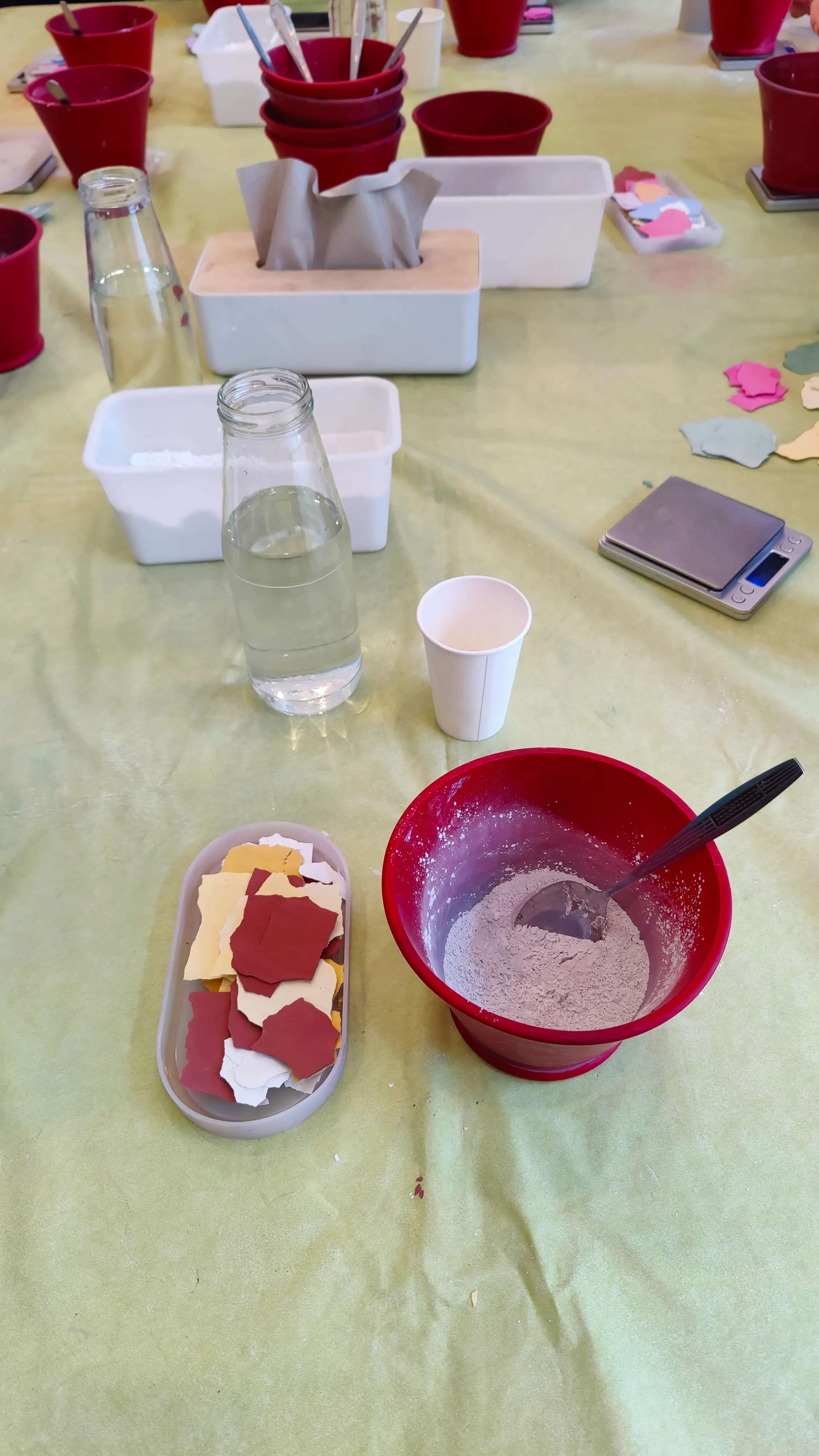 Craft table with paper, glue, and bottles.