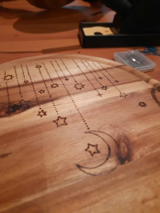 Wood board with stars and crescent moon design.