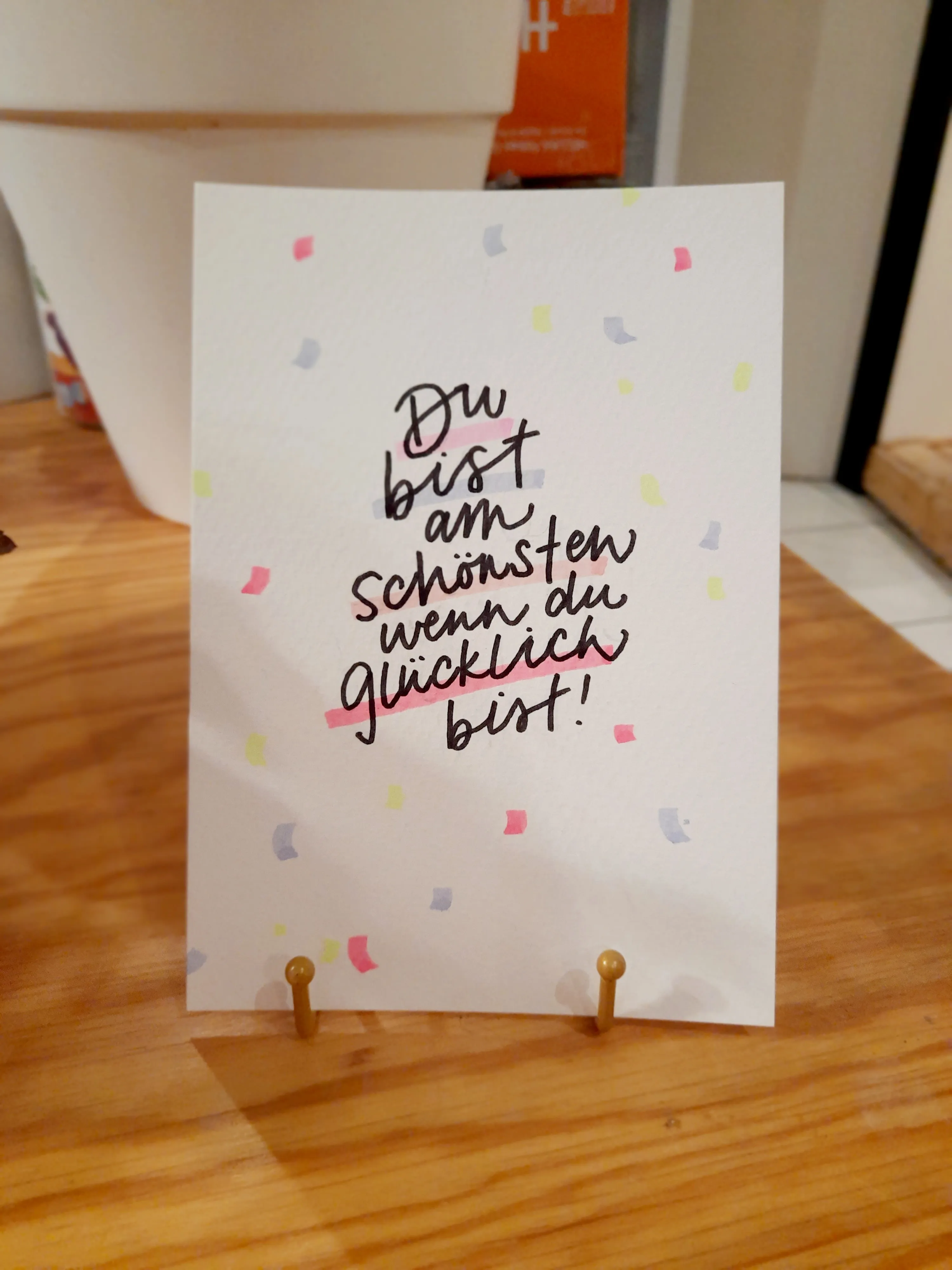 Dekokarte mit deutschem Text auf Tisch.