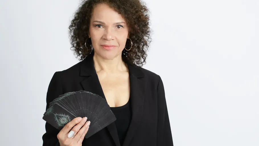 Frau hält Tarotkarten, weißer Hintergrund.