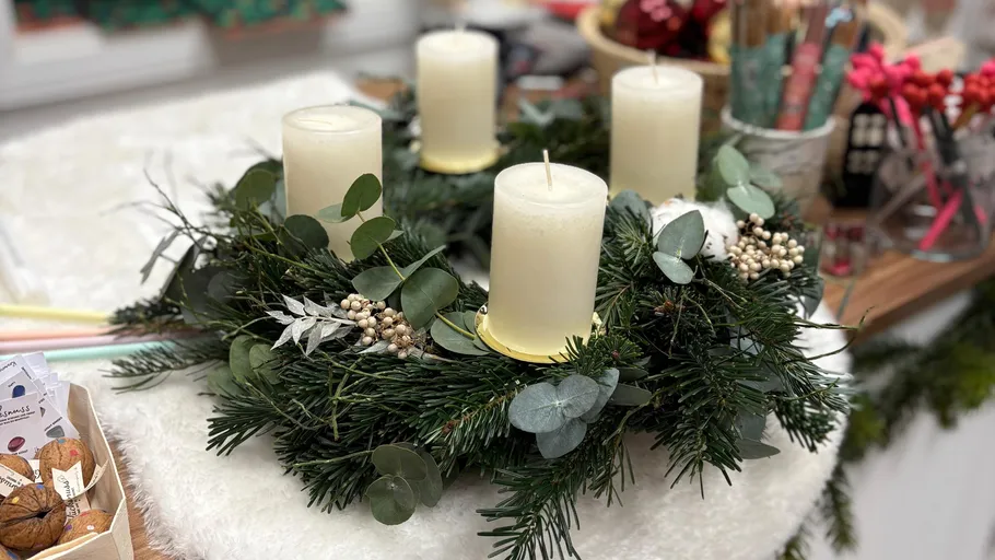 Candle wreath on table with decorations.