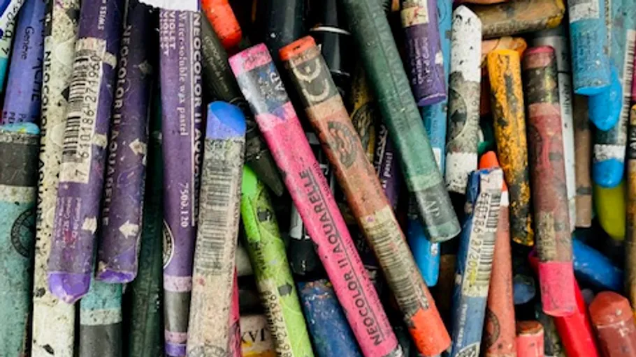 Bunte Wachsmalstifte zufällig auf Oberfläche verstreut.