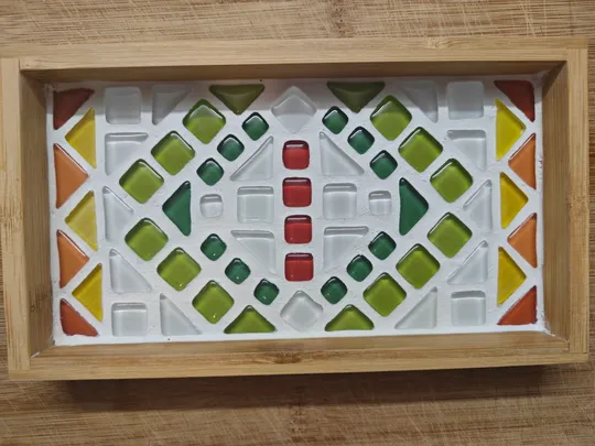 Buntes geometrisches Mosaik im Holzrahmen.