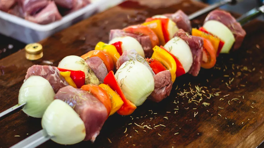 Spieße mit Fleisch und Gemüse auf Holz.