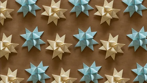 Origami-Sterne auf brauner Oberfläche angeordnet.