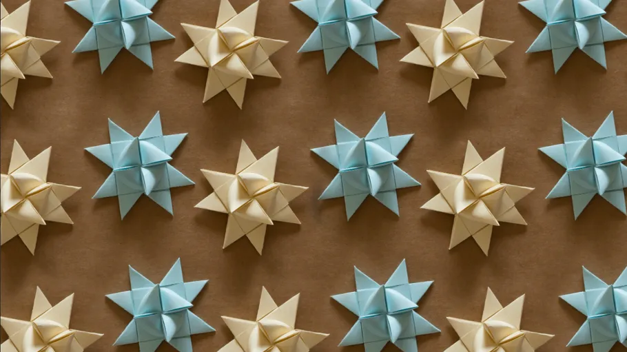 Origami-Sterne auf brauner Oberfläche angeordnet.