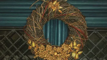 Wreath with golden flowers on door.