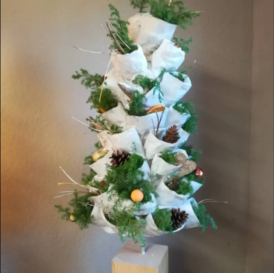 Artistic tree with decorations indoors.