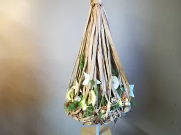 Wicker lamp with lights and decorations hanging.
