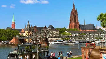 Brücke über Fluss mit Dom und Gebäuden.