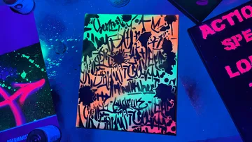 Graffiti art illuminated under blacklight glow.