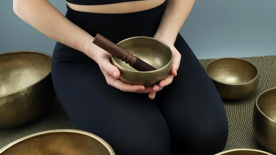 Person holding a singing bowl indoors.
