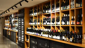 Wine bottles displayed on wooden shelves in a store.