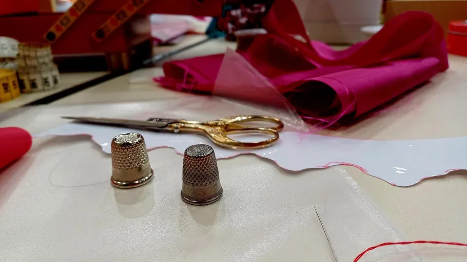 Nähwerkzeuge und Stoffe auf einem Tisch.