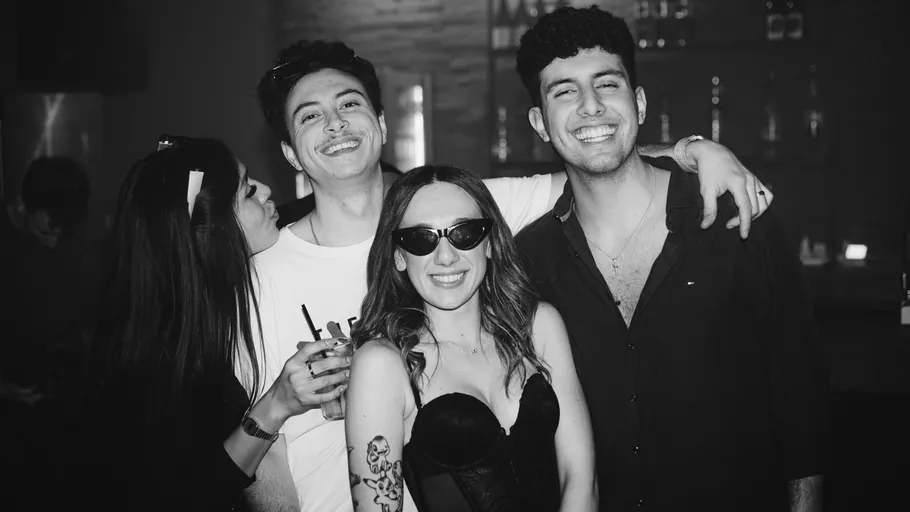 Group of four friends smiling in bar.