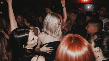 People dancing enthusiastically in crowded club.