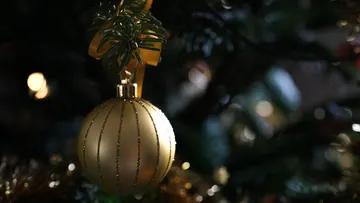 Goldene Kugel hängt am Weihnachtsbaum.