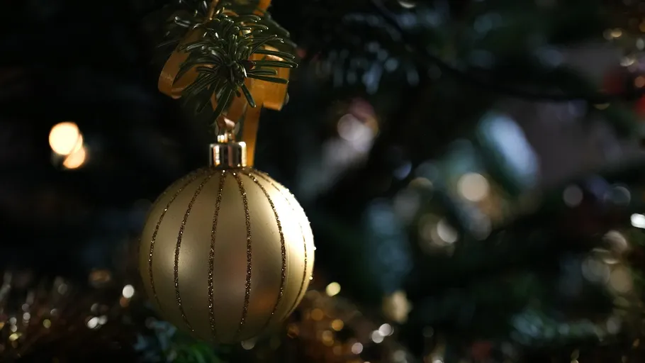 Goldener Anhänger am Weihnachtsbaum hängend.